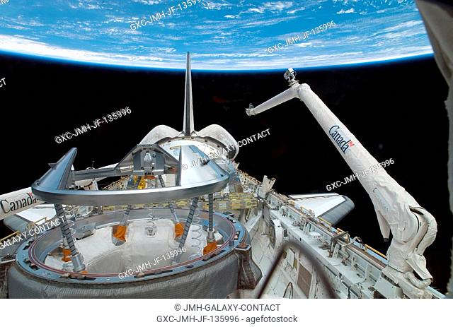 Backdropped by the blackness of space and Earth's horizon, Atlantis' orbiter docking system (foreground) and the Canadarm Remote Manipulator System (RMS) in the...