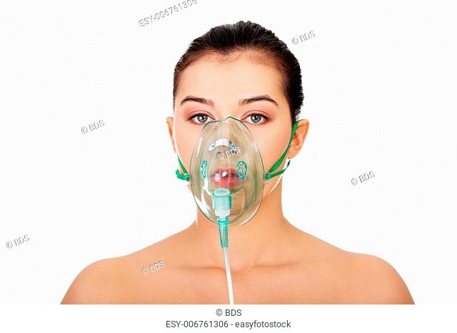Diseased female patient wearing a oxygen mask against white background