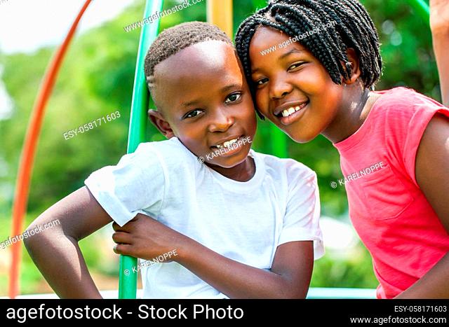 Close up face shot portrait of African kids joining heads in park