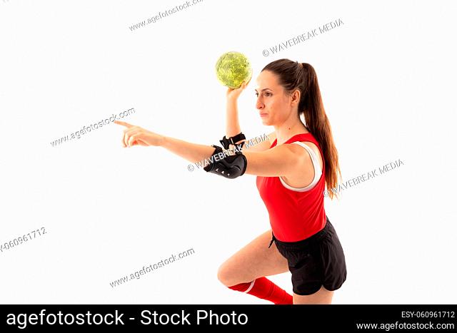 Caucasian young female player with arm outstretched and handball against white background