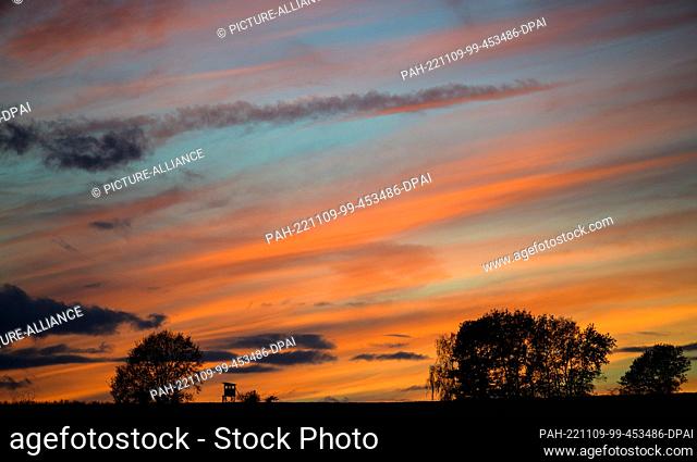 09 November 2022, Lower Saxony, Hitzacker: The rays of the sun that has just set turn the clouds in the sky red. Photo: Philipp Schulze/dpa