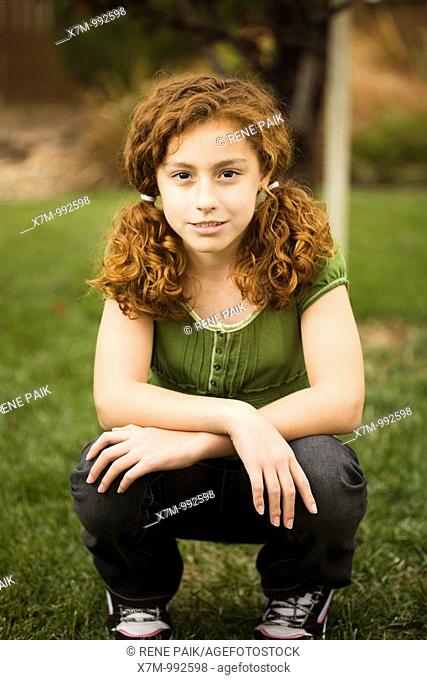 Smiling red-headed young mixed race mexican & caucasian girl in pigtails