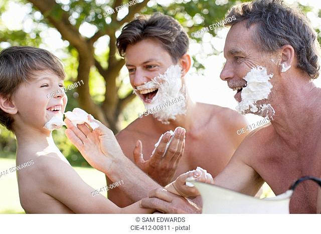 Playful multi-generation men applying shaving cream to faces
