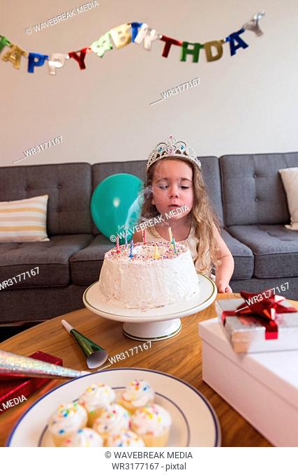 Little girl blowing out the candles on her birthday cake