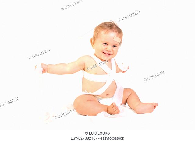 Cute baby boy playing with bandages in a first aid kit