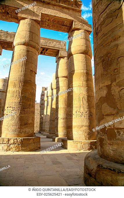 big stone columns with carving figures and hieroglyphs in landmark Egyptian Karnak Temple, public ancient monument declared a World Heritage by Unesco, in Luxor