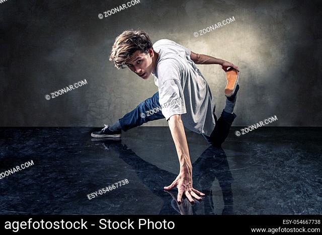 urban hip hop dancer with grunge concrete wall background texture jumping and dancing