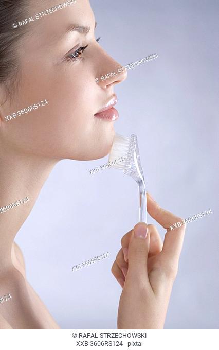 woman with face cleaning brush