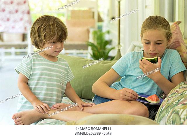 Caucasian brother and sister watching digital tablet on sofa