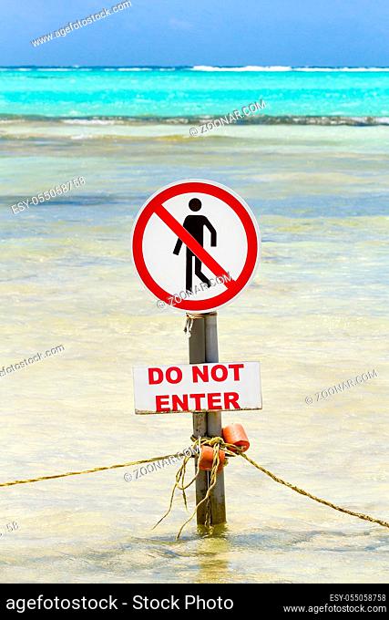 Warning sign by the sea with text do not enter