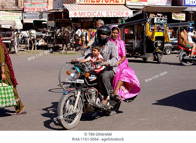 Indian family riding motorcycle, street scene at Sardar Market at Girdikot, Jodhpur, Rajasthan, Northern India