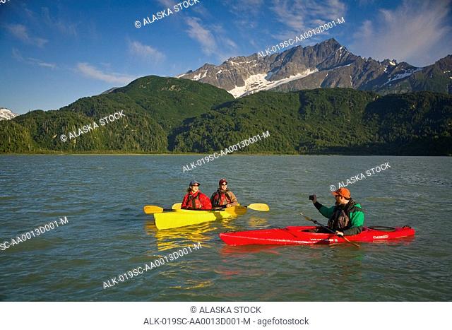 Kayakers on Big River Lakes with Chigmit Mountains in the background in the Redoubt Bay State Critical Habitat Area during Summer in Southcentral Alaska