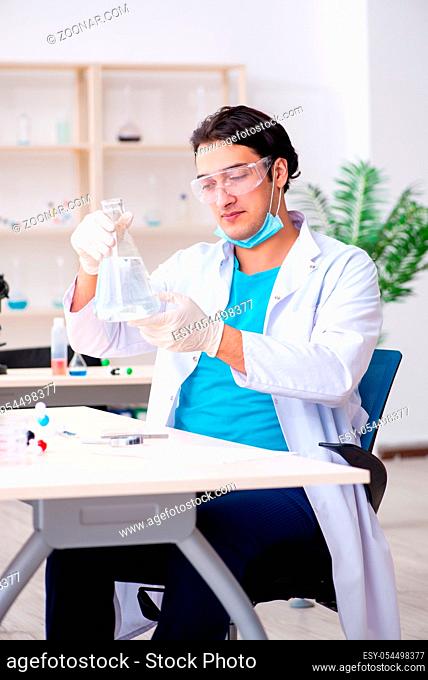 The young male chemist working in the lab