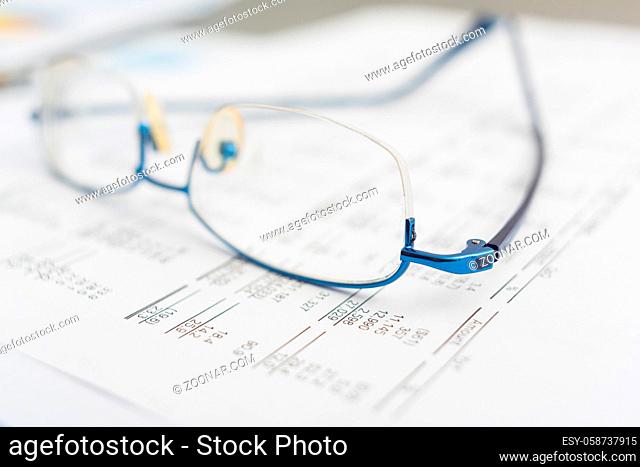 glasses on the finance chart on the desk