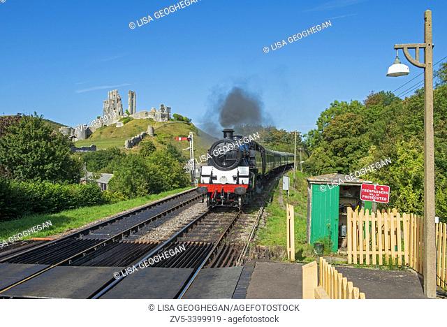 Locomotive 80104 steam train at Corfe railway station with Corfe Castle in the background. Corfe, Isle of Purbeck, Dorset, Uk