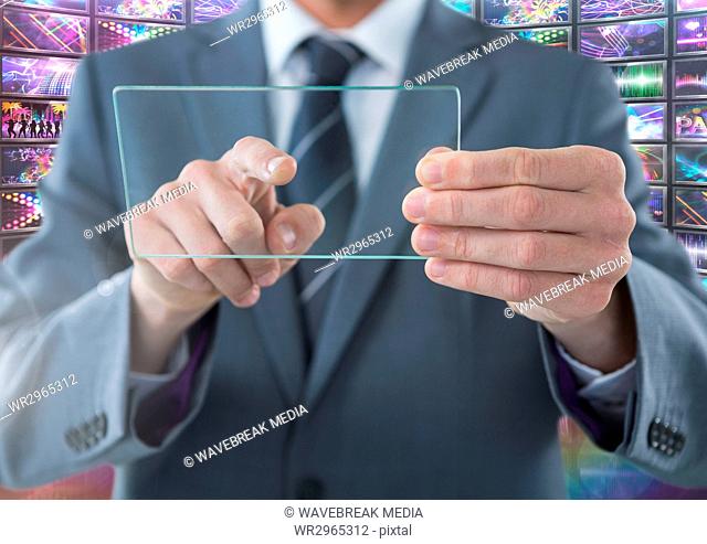 Businessman holding glass screen with colorful screens visuals