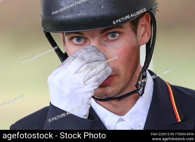 15 September 2022, Italy, Rocca Di Papa: Equestrian sport: World Championship, Eventing, Dressage. Dressage rider Christoph Wahler (Germany) grabs his nose...