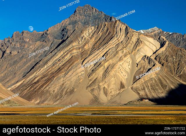 Impressive cliff in the Zanskar Mountains of the Himalayas with folded strata (rock layers) of the sediment or metamorphic rocks