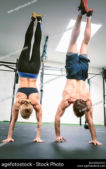 Couple in gym training handstands