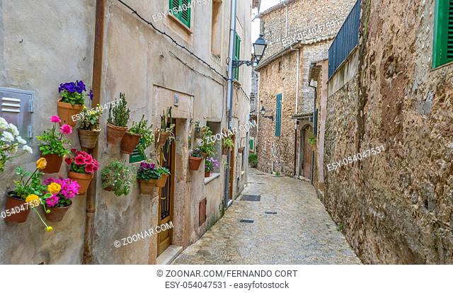 Travel Beautiful street in Valldemossa with traditional flower decoration, famous old mediterranean village of Majorca. Balearic island Mallorca, Spain