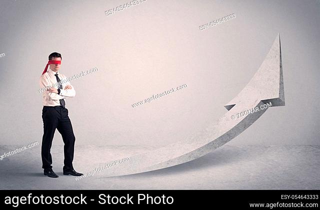 A scared blindfolded businessman forced to face a problem concept with illustrated arrow pointng to the sky in empty space