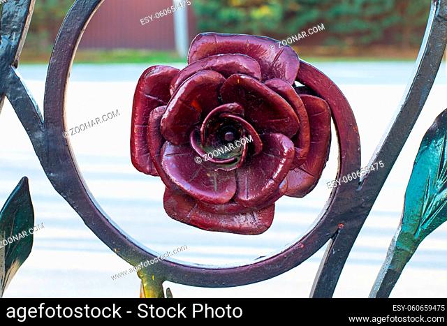 Metallic rose burgundy color, forged floral decoration close-up