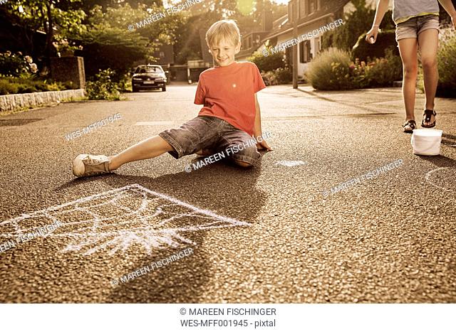 Children using sidewalk chalk in their neighborhood