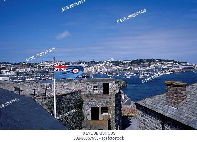 St Peter Port. View from Castle Cornet with Union Jack flying. Marina and quayside buildings in the distance