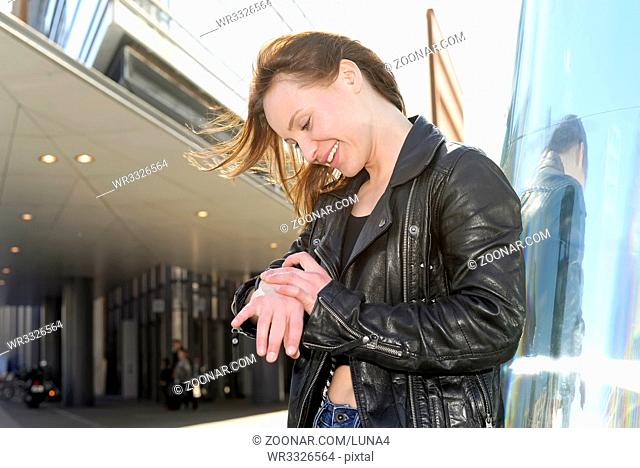 Frau schaut auf Uhr  happy young woman looking at watch