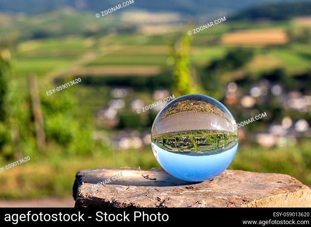 Crystal ball on shale stone with defocused river Moselle valley in background