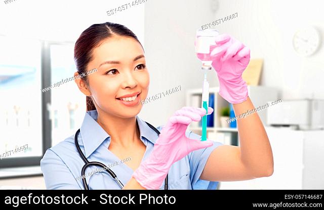 happy asian female nurse with medicine and syringe