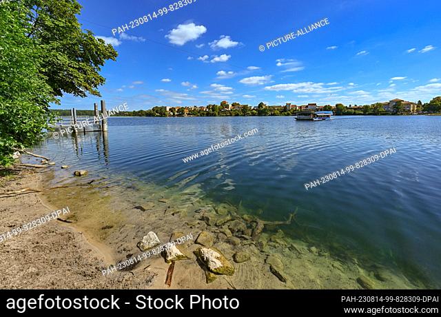 PRODUCTION - 11 August 2023, Brandenburg, Strausberg: A cable ferry crosses Lake Straus. The lake has lost half of its water for about ten years