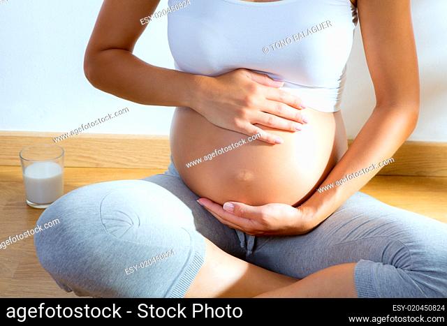 Beautiful pregnant woman massage her belly