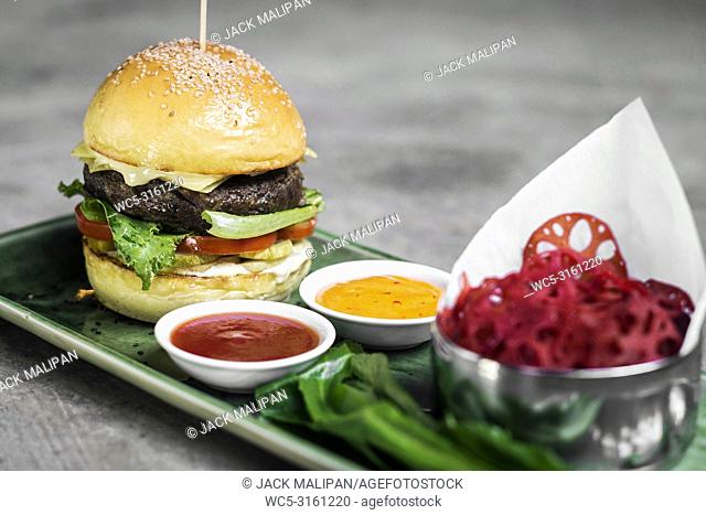 modern fusion beef burger set with lotus chips ketchup and spicy chlli sauces