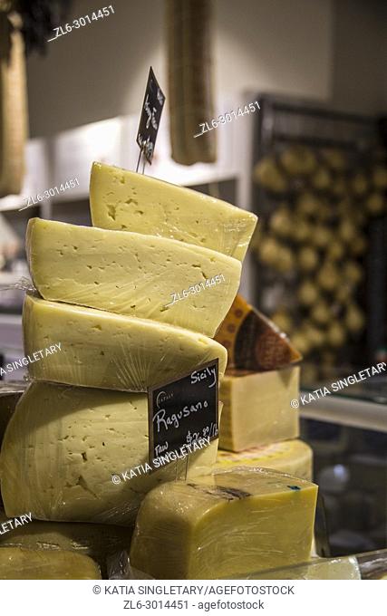 A bunch of cut assorted italian cheese, stacked on top of each other waiting to be bought