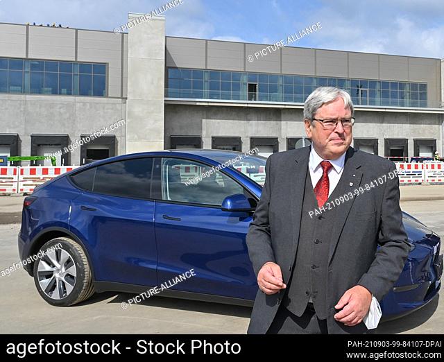 01 September 2021, Brandenburg, Grünheide: Jörg Steinbach (SPD), Minister of Economics of Brandenburg, stands next to a Tesla Model Y at the construction site...