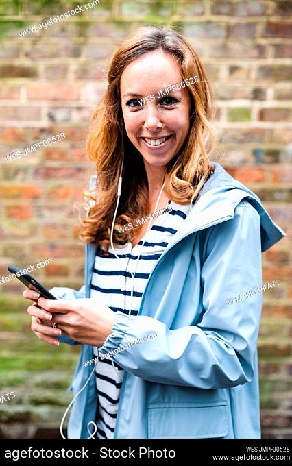 Female tourist using mobile phone while exploring city