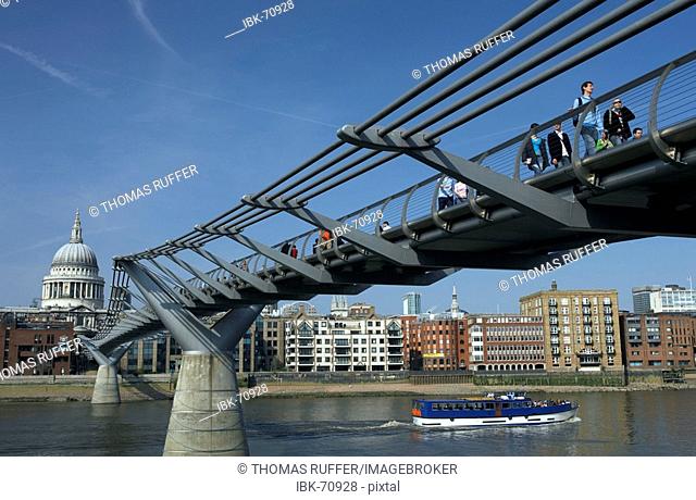 The Millenium Bridge, built for the turn of the century, spanning the Thamse, with pedestrians and view of the City, London, Great Britain