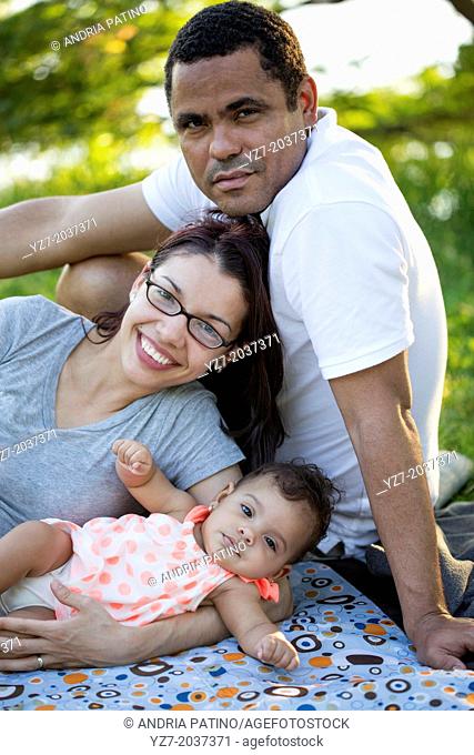 Parents posing with 5 month old baby in park