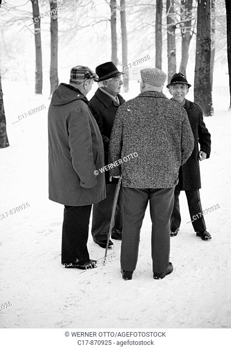 Seventies, black and white photo, people, four older men take a walk, retired persons, winter, snow, walking stick, aged 65 to 75 years