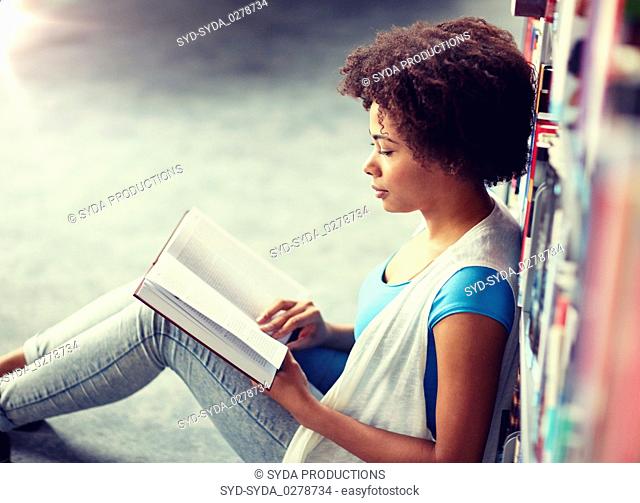 african student girl reading book at library