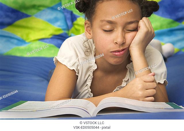 African American girl falling asleep doing homework