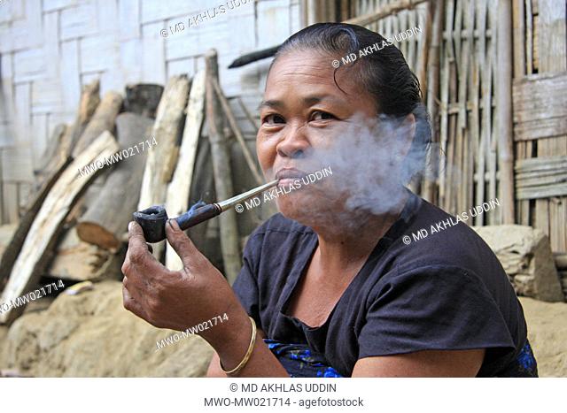 An elderly woman from ethnic community smokes a pipe Tidu in Bandarban, Bangladesh December 4, 2009