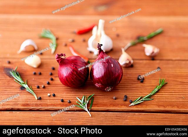 onion, garlic, chili pepper and rosemary on table