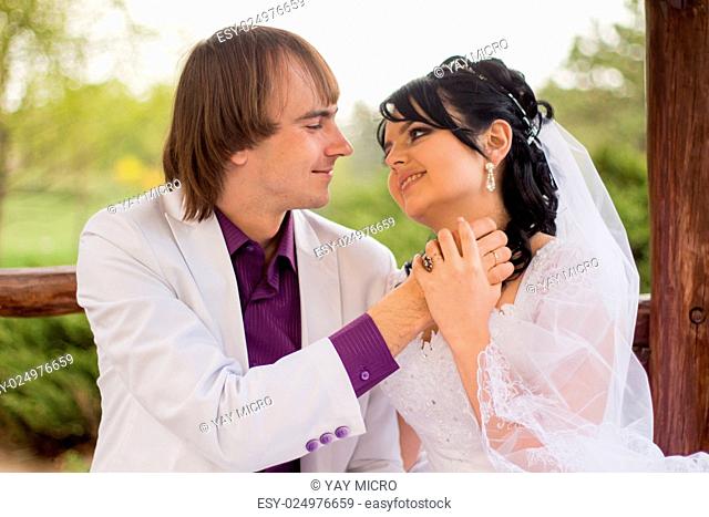 Couple love bride and groom posing sitting on wooden bench in