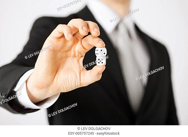 close up of mans hand holding white casino dice