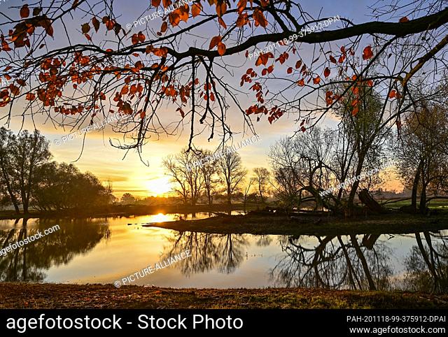 15 November 2020, Brandenburg, Lebus: The morning sky shines colourfully over the meadows partially flooded by the floods of the German-Polish border river Oder