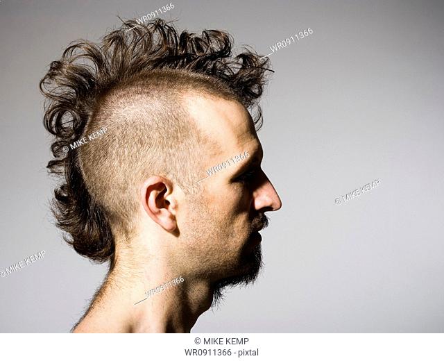 Side profile of man with half shaved hair and beard