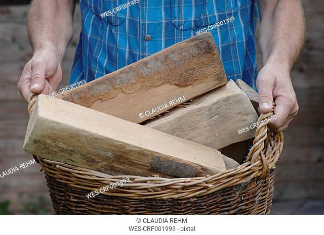 Germany, Bavaria, Man carrying a woods in basket