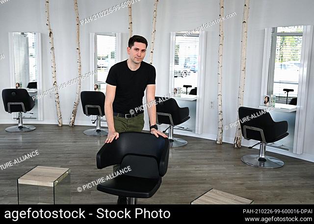 23 February 2021, Hessen, Seeheim-Jugenheim: Konstantin Schick, owner of the salon ""Schick Friseure"", stands in front of the empty chairs in his shop